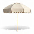 Outdoor patio umbrella in beige with wooden pole and scalloped edges